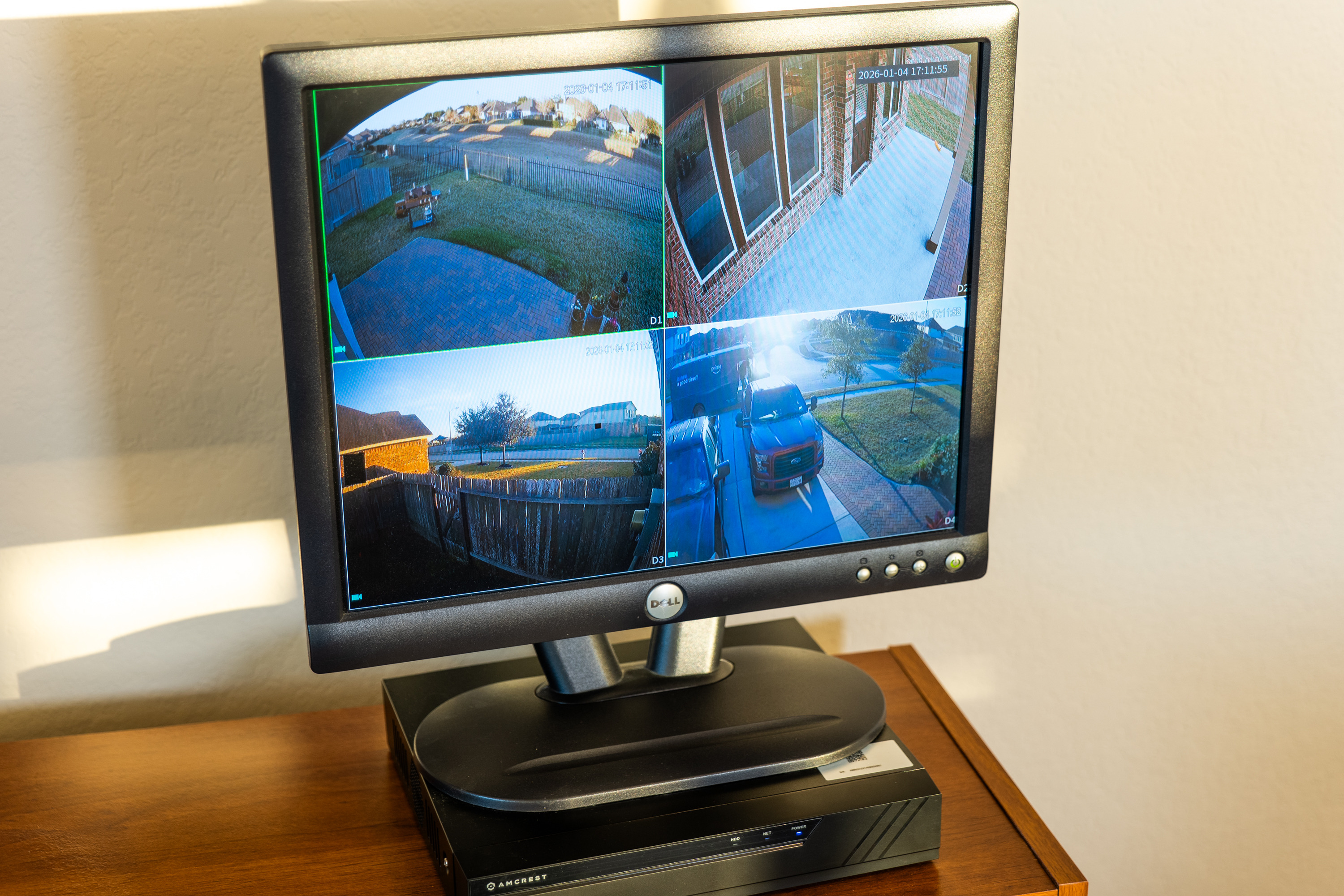 Security camera monitor and network video recorder showing four security camera views.
